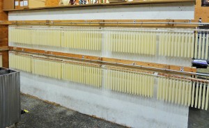壁一面に吊られた製造段階の異なるテーパーキャンドル