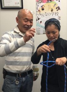 ▲︎参加者にロープの結び方を教える 杉本さん（左）