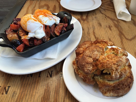 ▲季節の野菜、ポテトのグリルにポーチドエッグを 添えたベジハッシュ（$11）。バターと自家製ジャムをはさんだオリジナルビスケット（$4.25）